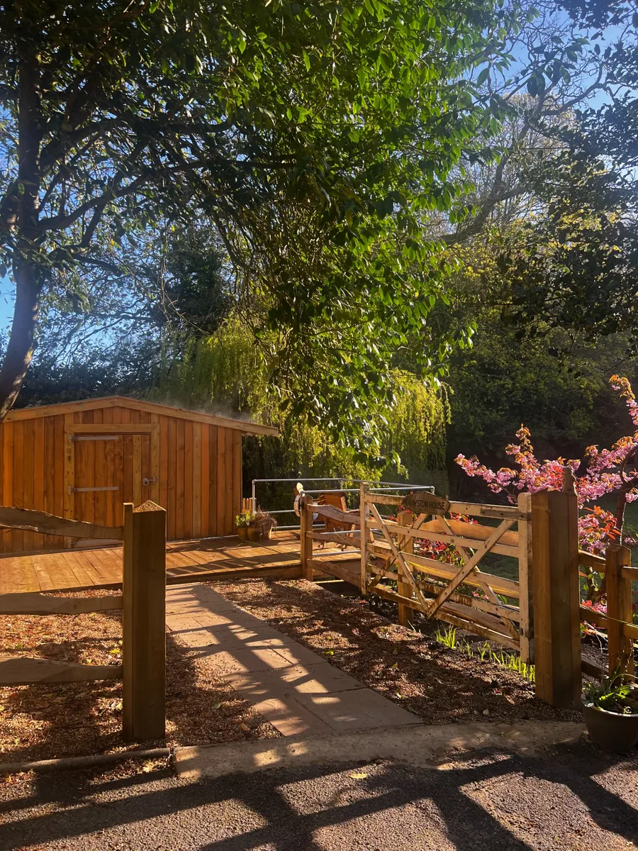 Timber gate and deck beside a wooden garden building