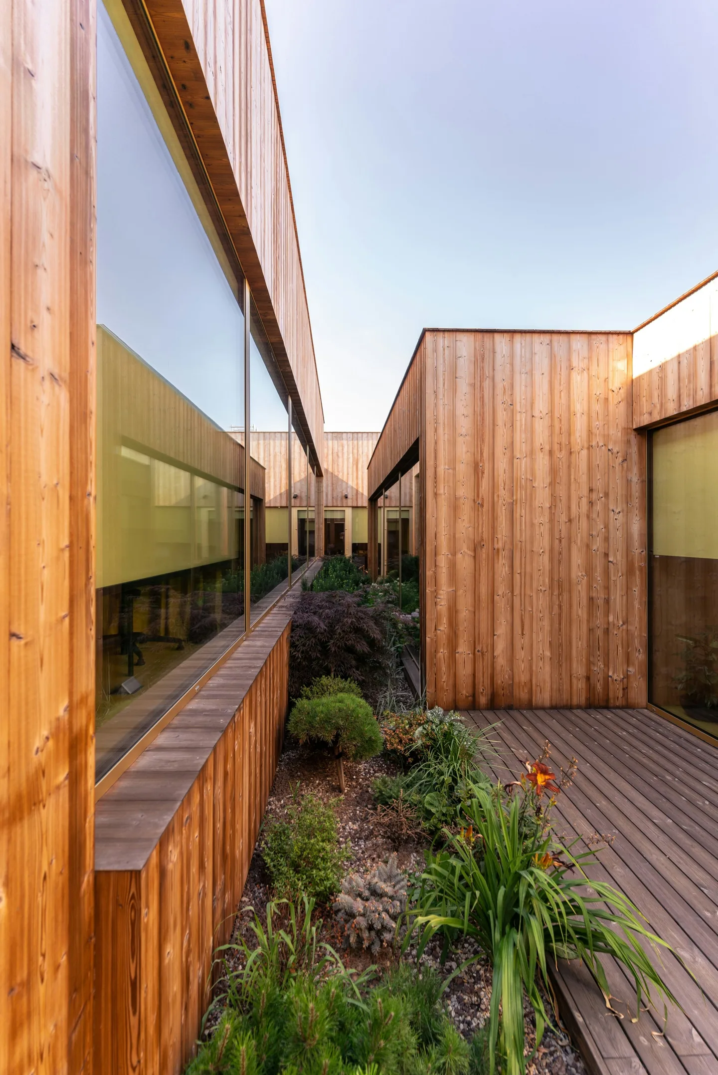 Timber-clad building beside a planted border
