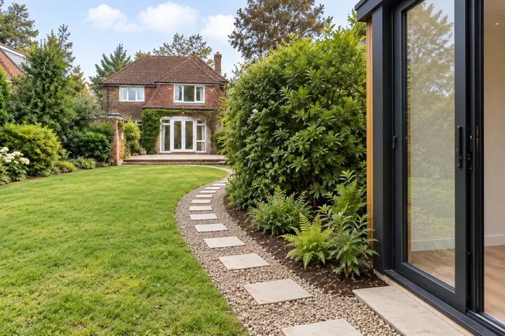 Stepping stones in a curved gravel path beside a garden room