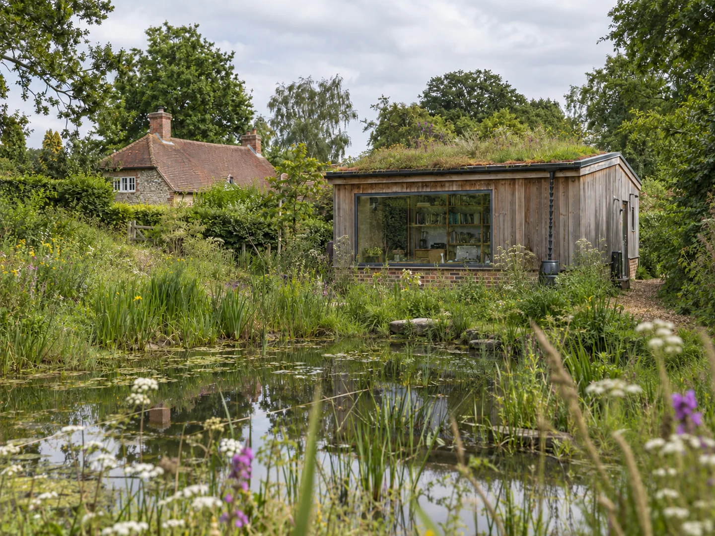 Garden building beside a planted wildlife pond