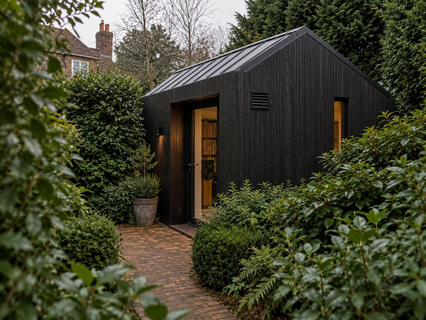 Dark timber cabin with pitched roof and a sheltered garden entrance